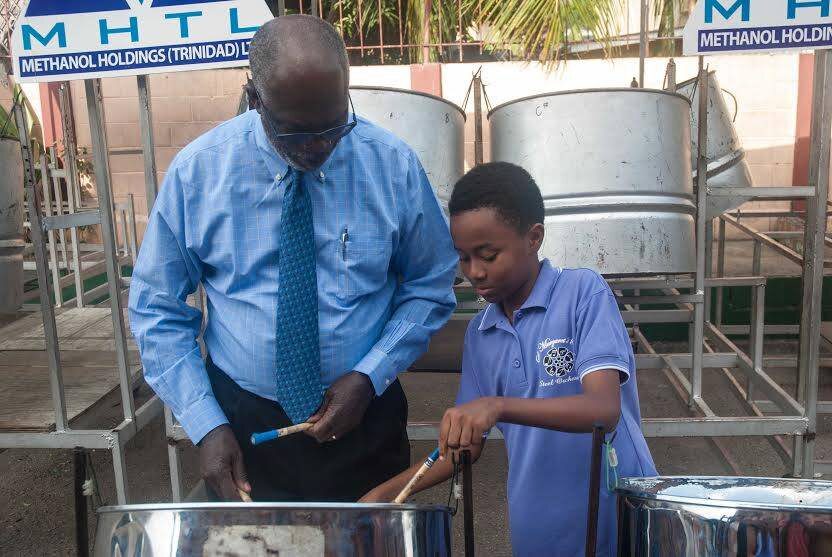  MHTL’s Chairman, Dr. Euric Bobb, receives his first steel pan lesson from young talent Kerneil Scipio 
