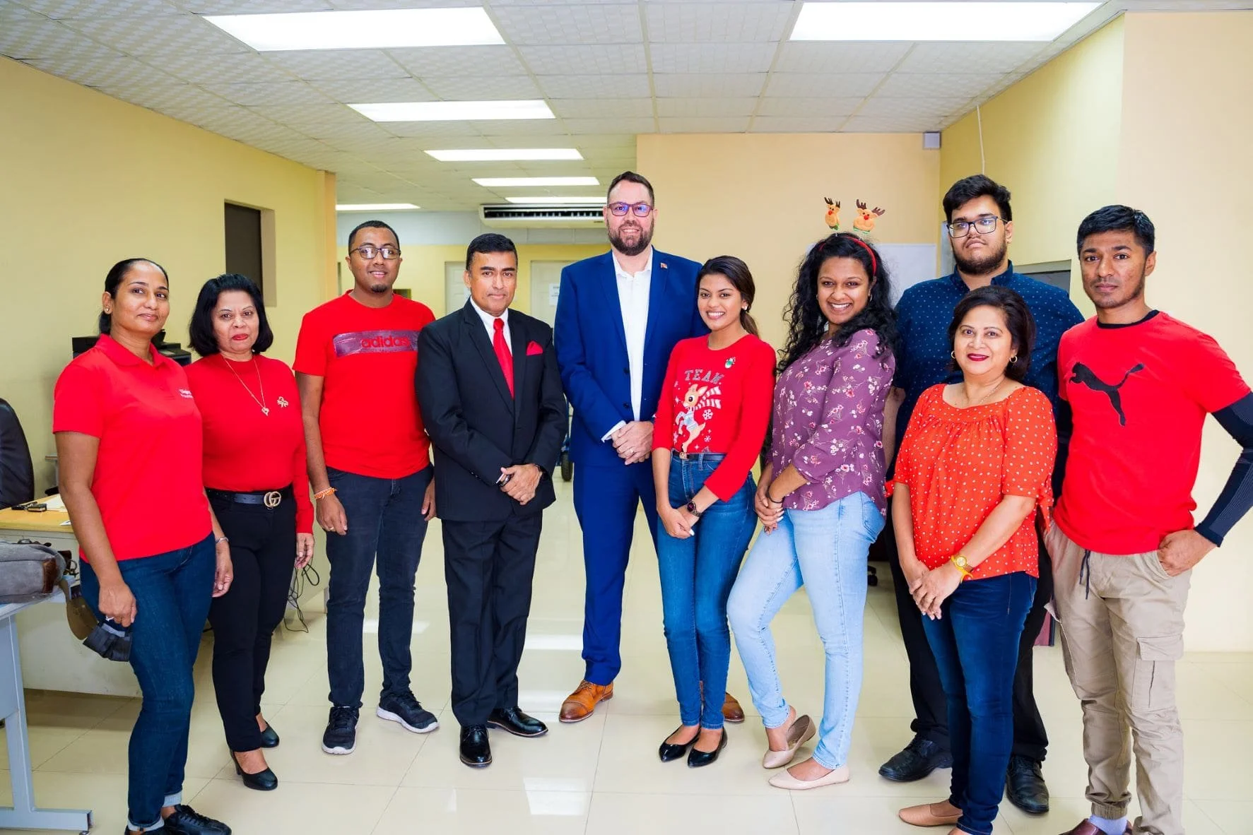 Digicel Chief Customer Officer, Kent Western, Member of Parliament for Oropouche West, Davendranath Tancoo, Office Staff, and Project Officer for the Digicel Foundation, Diana Mathura-Hobson, meet before heading out to distribute hampers, toys, treats and sorrel in Penal/Debe (5th from left)