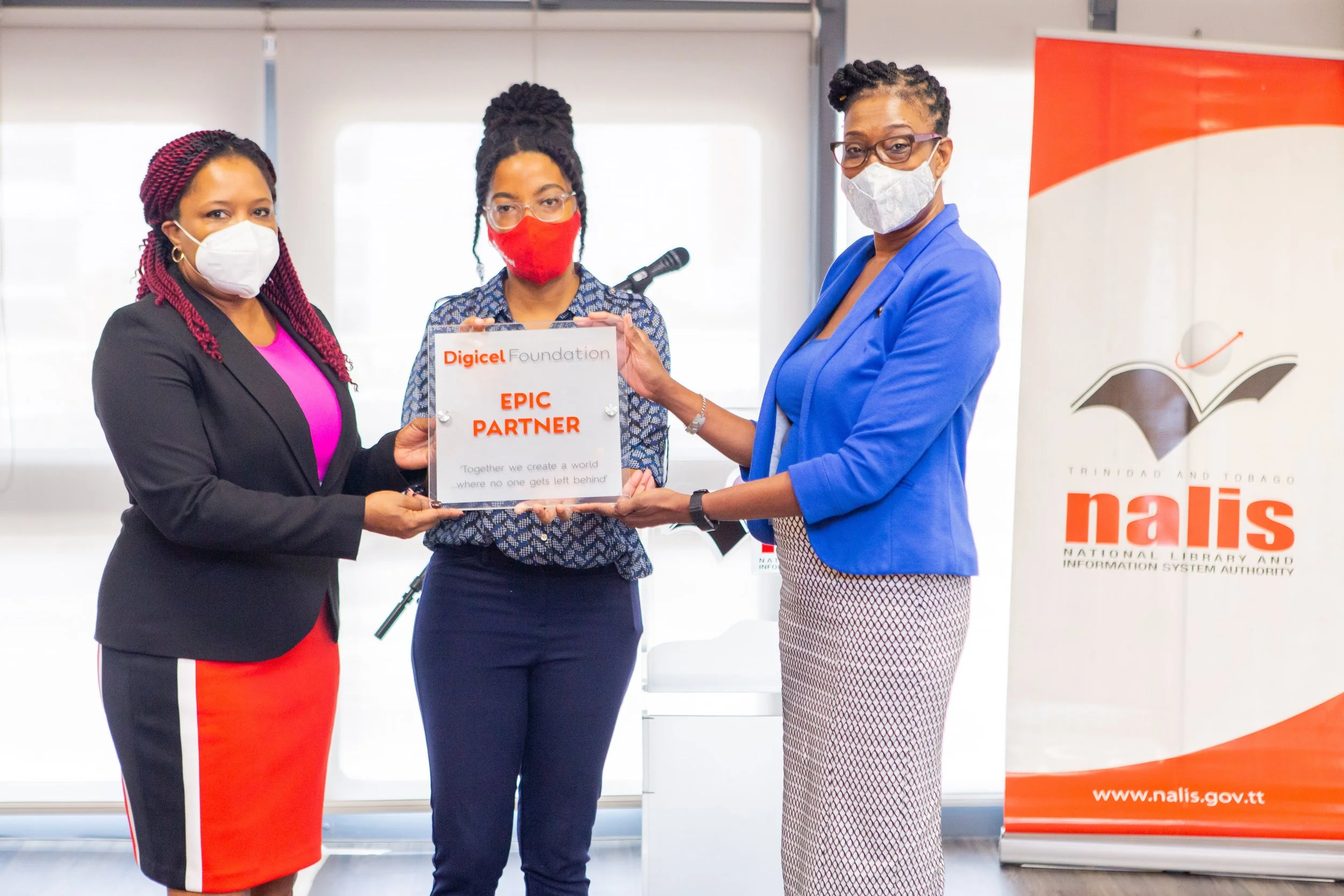 (L-R )Cherylann Quamina- Baptiste – Director of Heritage Library, Digicel Foundation Finance Accountant, Misha Jackman and Debbie Goodman, NALIS Manager- Corporate Communications display the EPIC partner plaque.