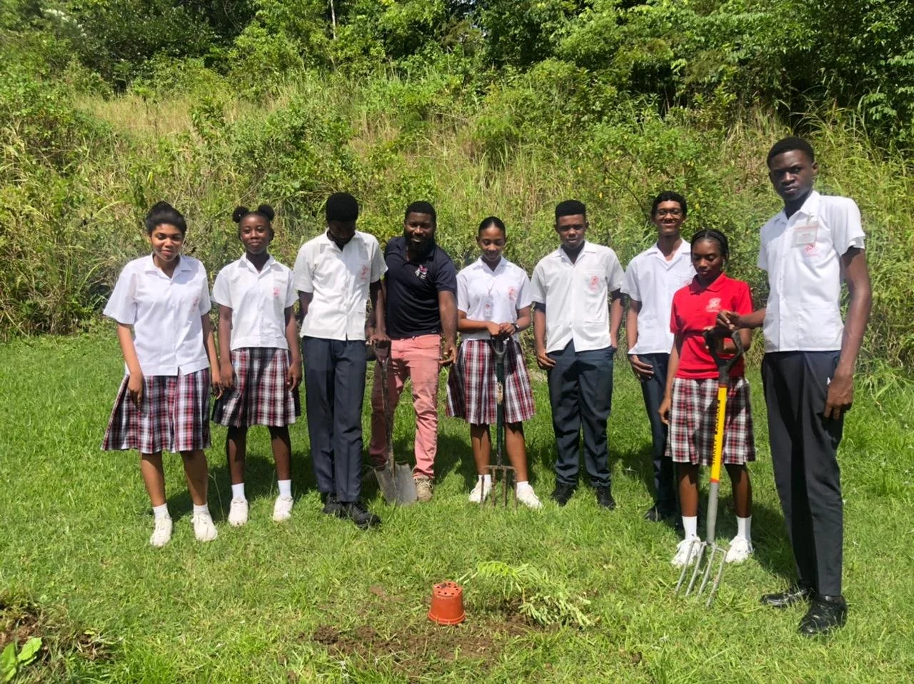 Ready, set, plant...students from Mason Hall Secondary stand proudly with their newly planted Flamboyant tree.