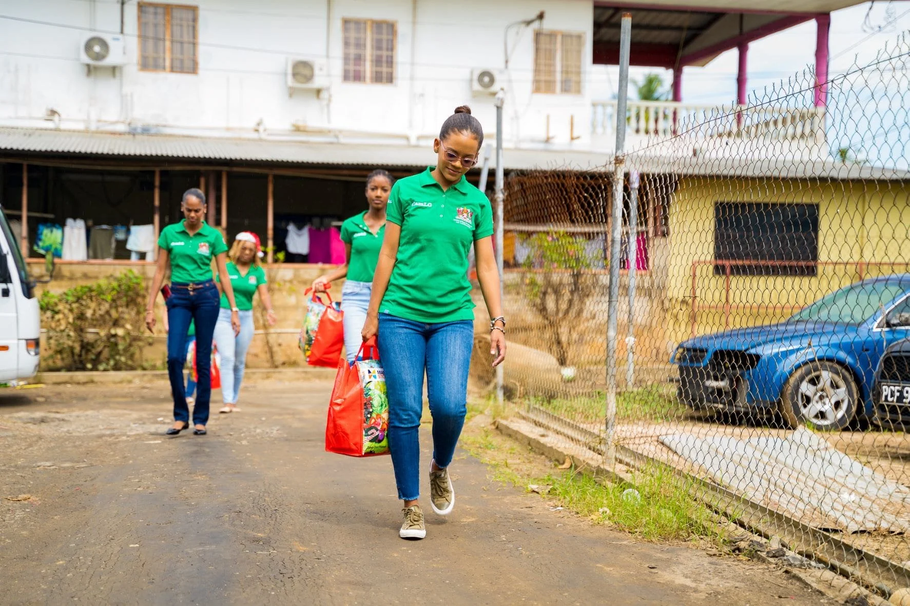 Members of the Communications Department, Ministry of Rural Development, and Local Government assist with hamper distribution in Bamboo Village.
