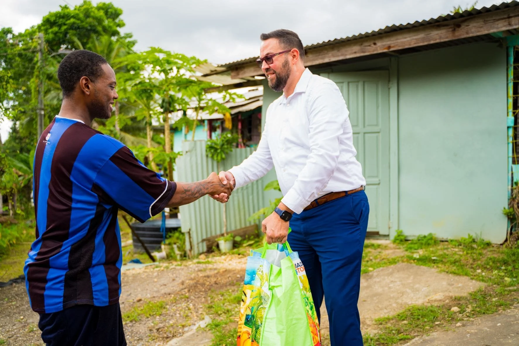 Digicel Chief Customer Officer, Kent Western (right) hands over a hamper to a Penal resident.
