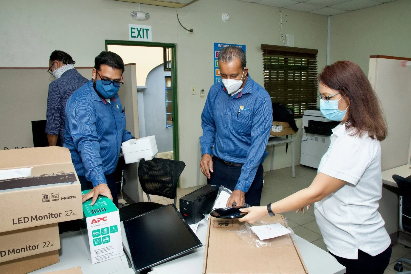 ( L-R) Varun Bhageraty, IGT Draw Coordinator, Clarance Baptiste, IGT Senior Comm Technician, and Cotton Tree Foundation’s Executive Director Sita Persad sort through equipment to be installed.
