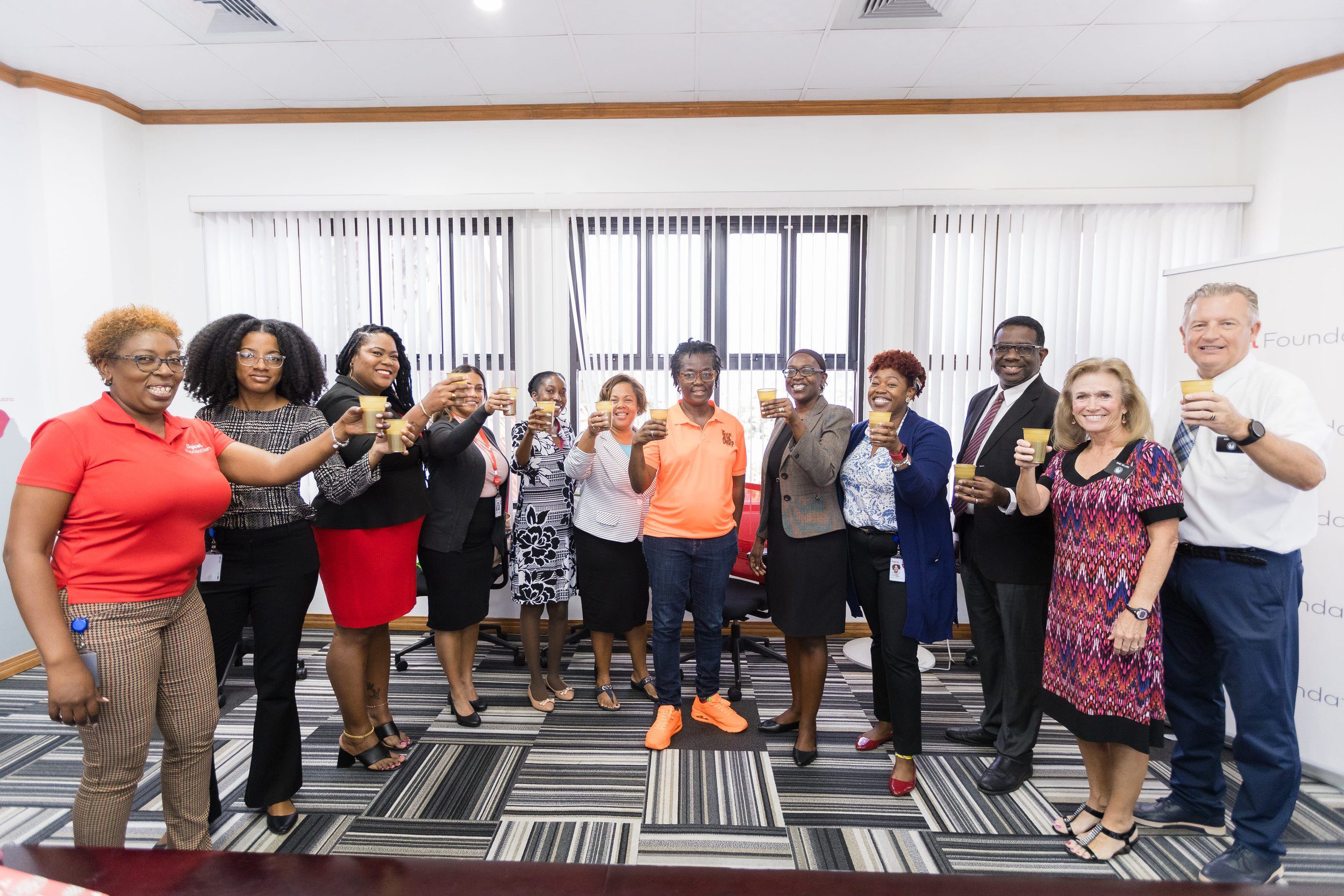  Representatives from the Digicel Foundation, The Church of Jesus Christ of Latter Day Saints and NGO beneficiaries celebrate their partnership with a toast of sorrel at the Digicel Foundation’s Headquarters on Tuesday 5 December. 