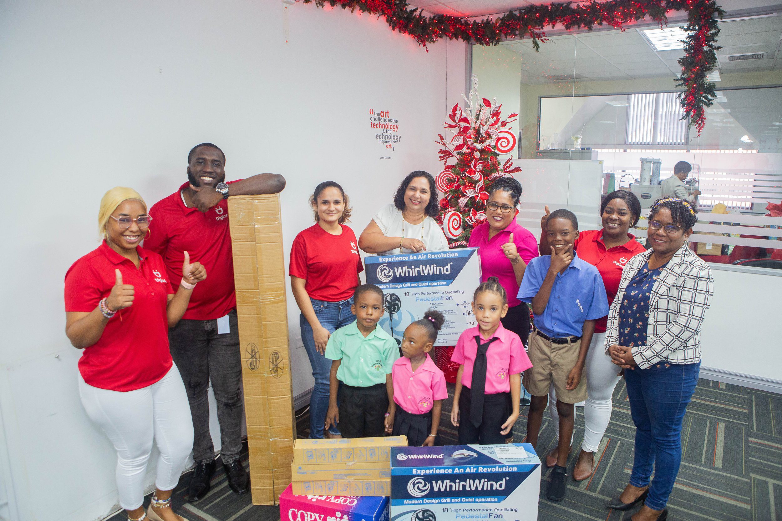 Principal Frances Gerais-Heath (on the far right) was joined by students of Nelson Street Boys Primary and SS Nursery and Preschool to receive the donation made to their schools by members of the Digicel Retention Team and the Digicel Foundation (in the back row).