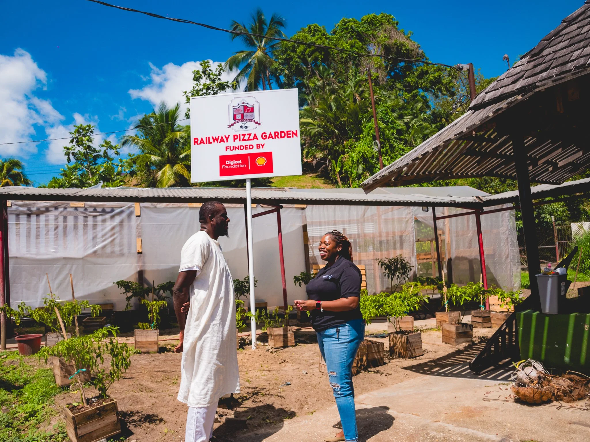  President of the Siparia Deltones, Akinola Sennon, leads Digicel Foundation’s Head of Operations Cindyann Currency on a tour of the Railway Pizza Garden at the Deltones Pan Yard on Railway Road Siparia in April 2024.  