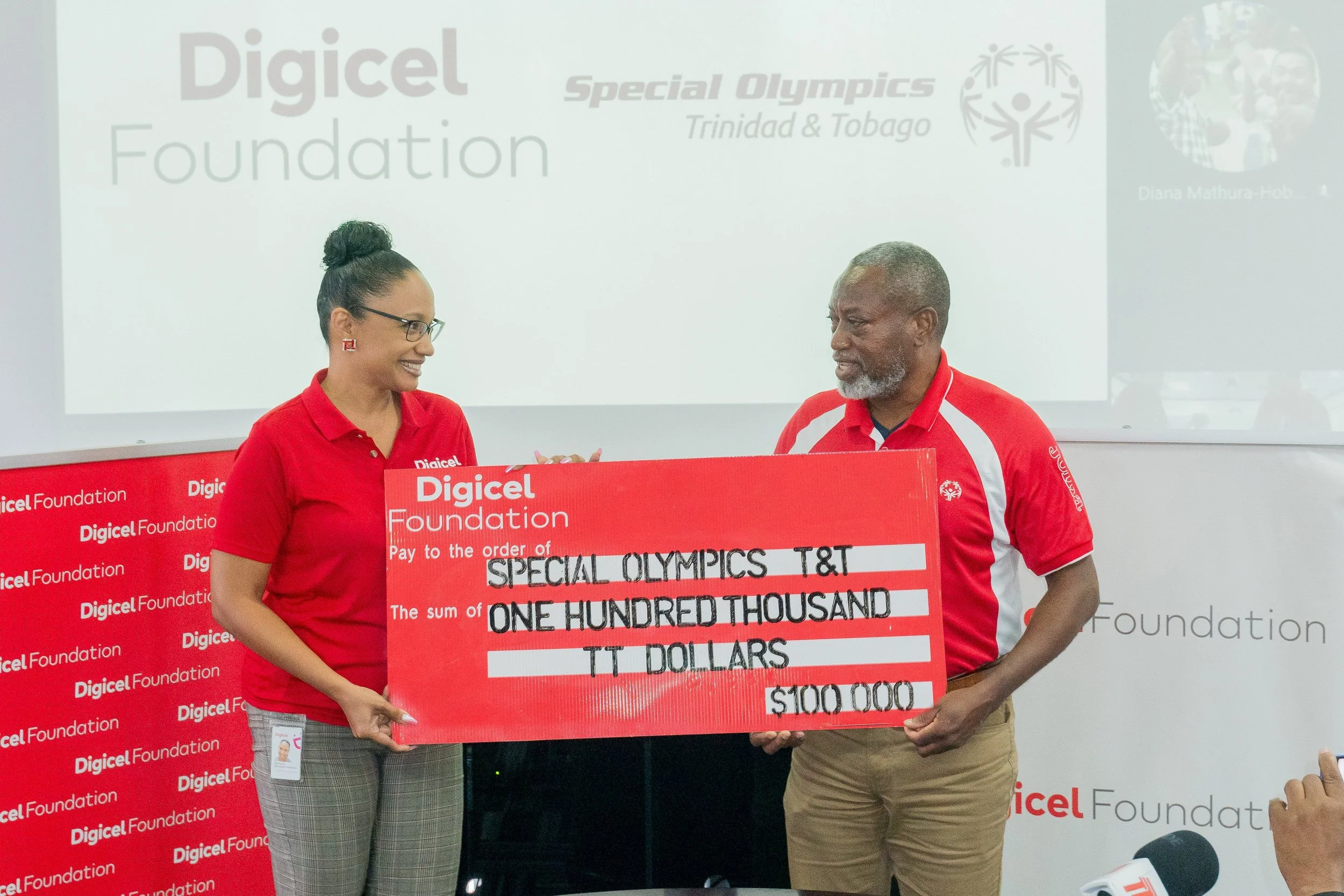 Digicel Foundation Director Romona Boisselle-Romano hands over a sponsorship pledge of TT$100,000 to the Special Olympics Trinidad and Tobago (SOTT) National Director Ferdinand Bibby for the 2024 SOTT National Games.