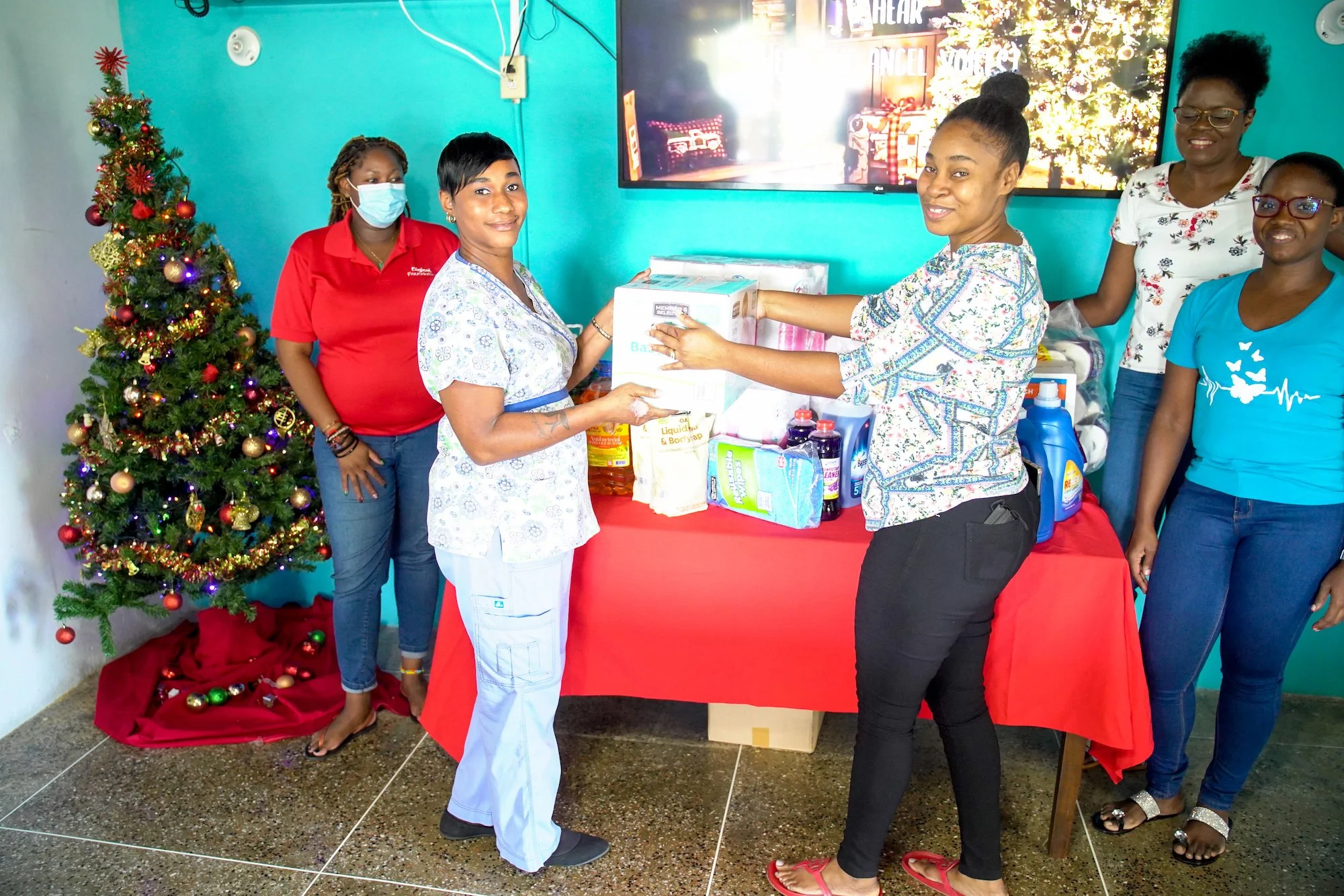 Nurse Candice Sebro (front left) receives a donation of essential items on behalf of Datta’s Home for the Aged from Digicel Business Risk Analyst Ria Moore-Best (front right). In the background (left to right) Cindyann Currency, Renis Gabriel and Shelly Ann Stewart are on hand to help.