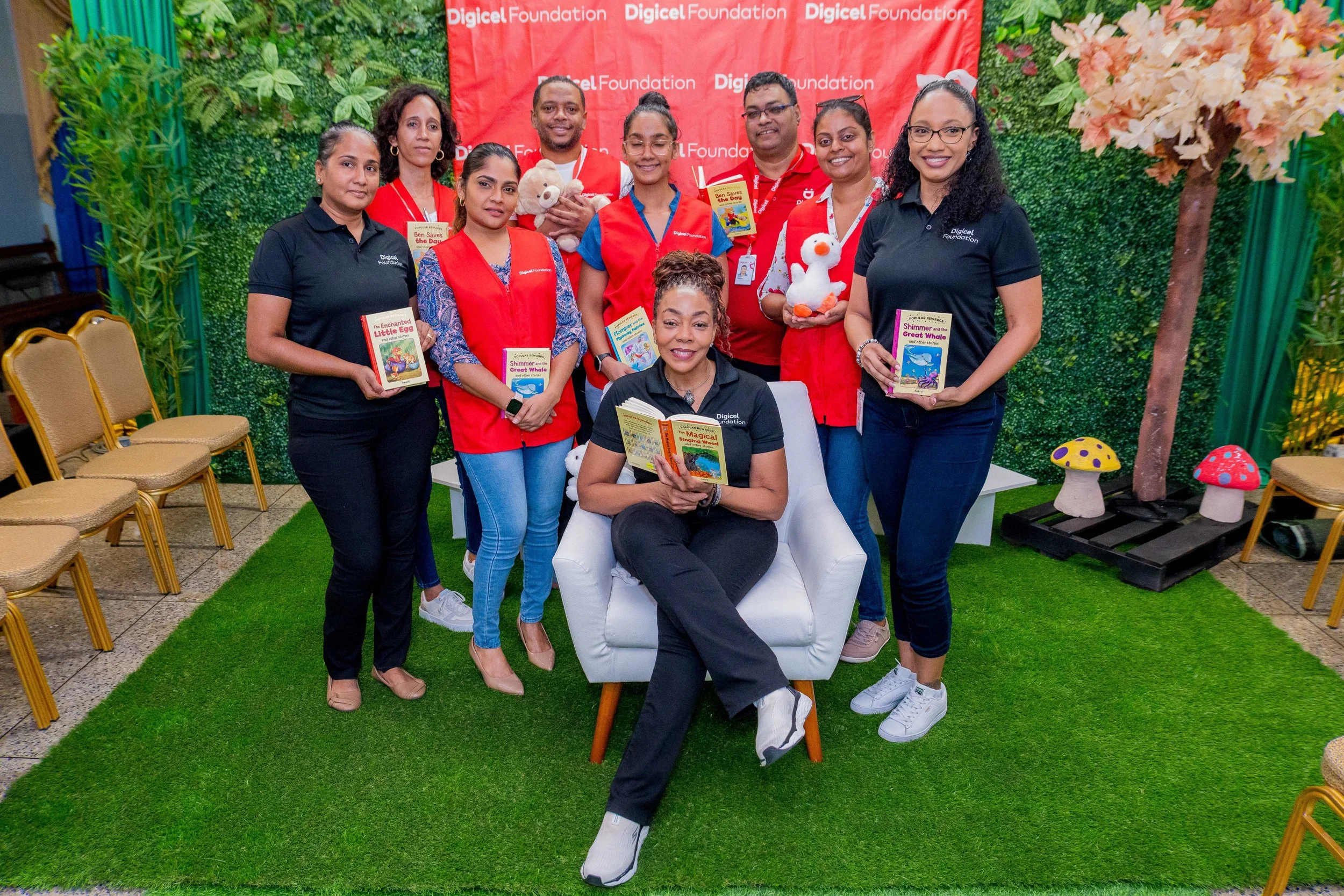 Digicel Foundation CEO Penny Gomez (seated in the centre) is joined by some of the day’s volunteer readers at the Digicel Foundation’s event ‘Unlocking Worlds: Literacy and Inclusion for All’.