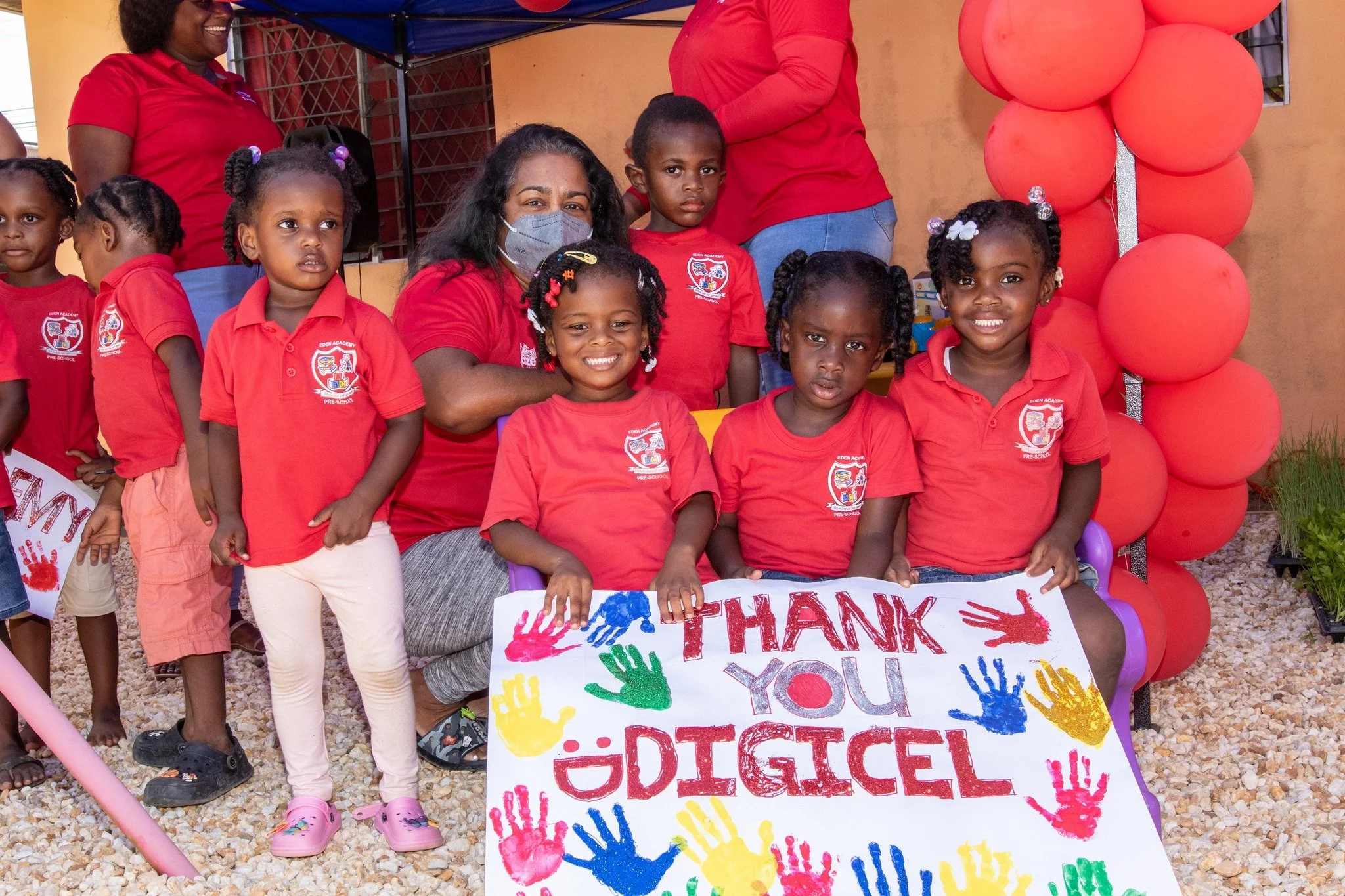  Showing their Appreciation! Kids from Eden’s Academy show off their “Thank You Digicel” artwork to the team of Digicel Retention Agents for enhancing their outdoor play area.     