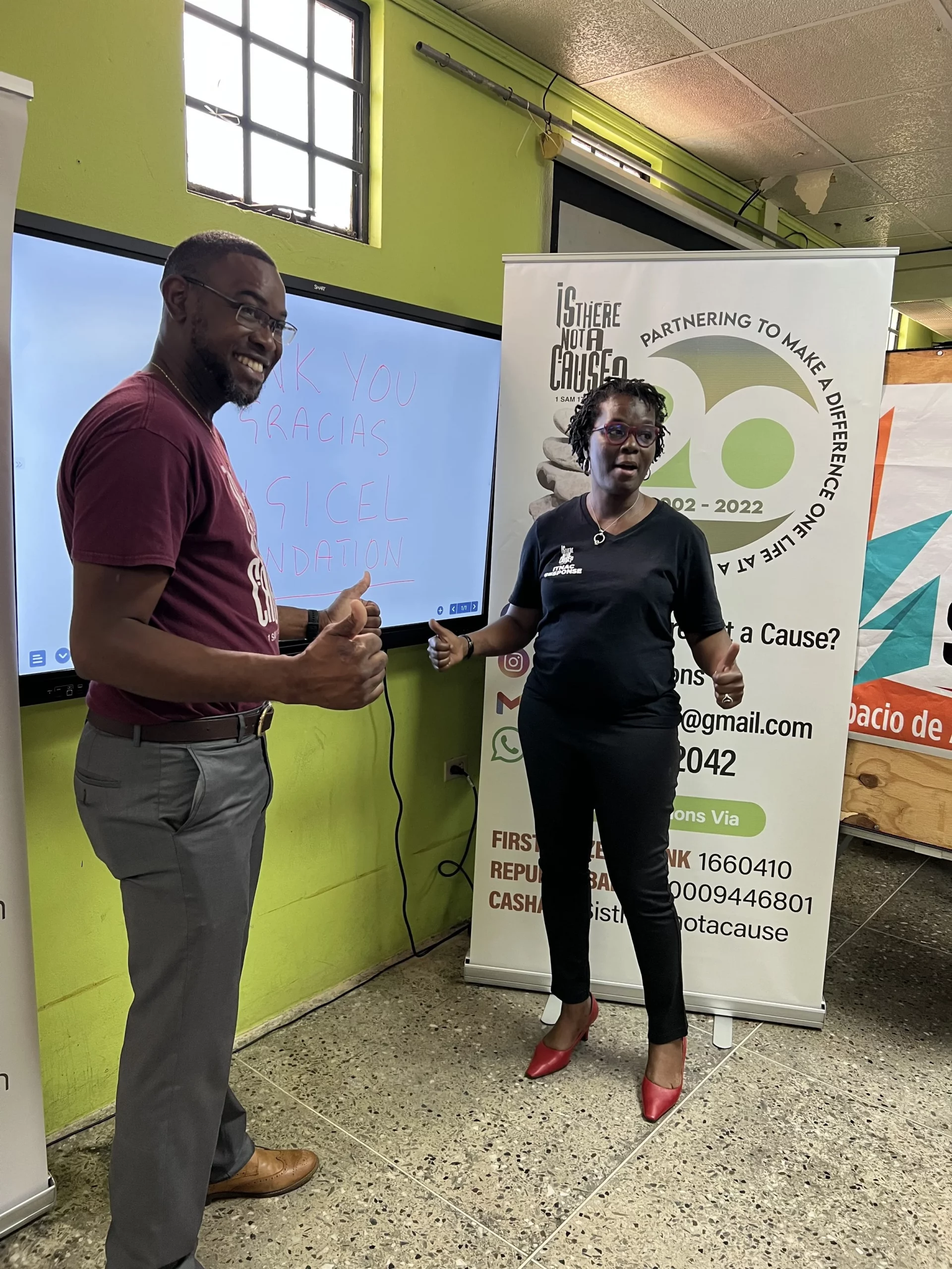 Christopher Joseph aka ChrisJay of 98.1 FM and Avonelle Hector Joseph, Founder of ITNAC, flash a thumbs up after the successful installation of the smart board in the learning space for migrant children at ITNAC’s The Love Centre.