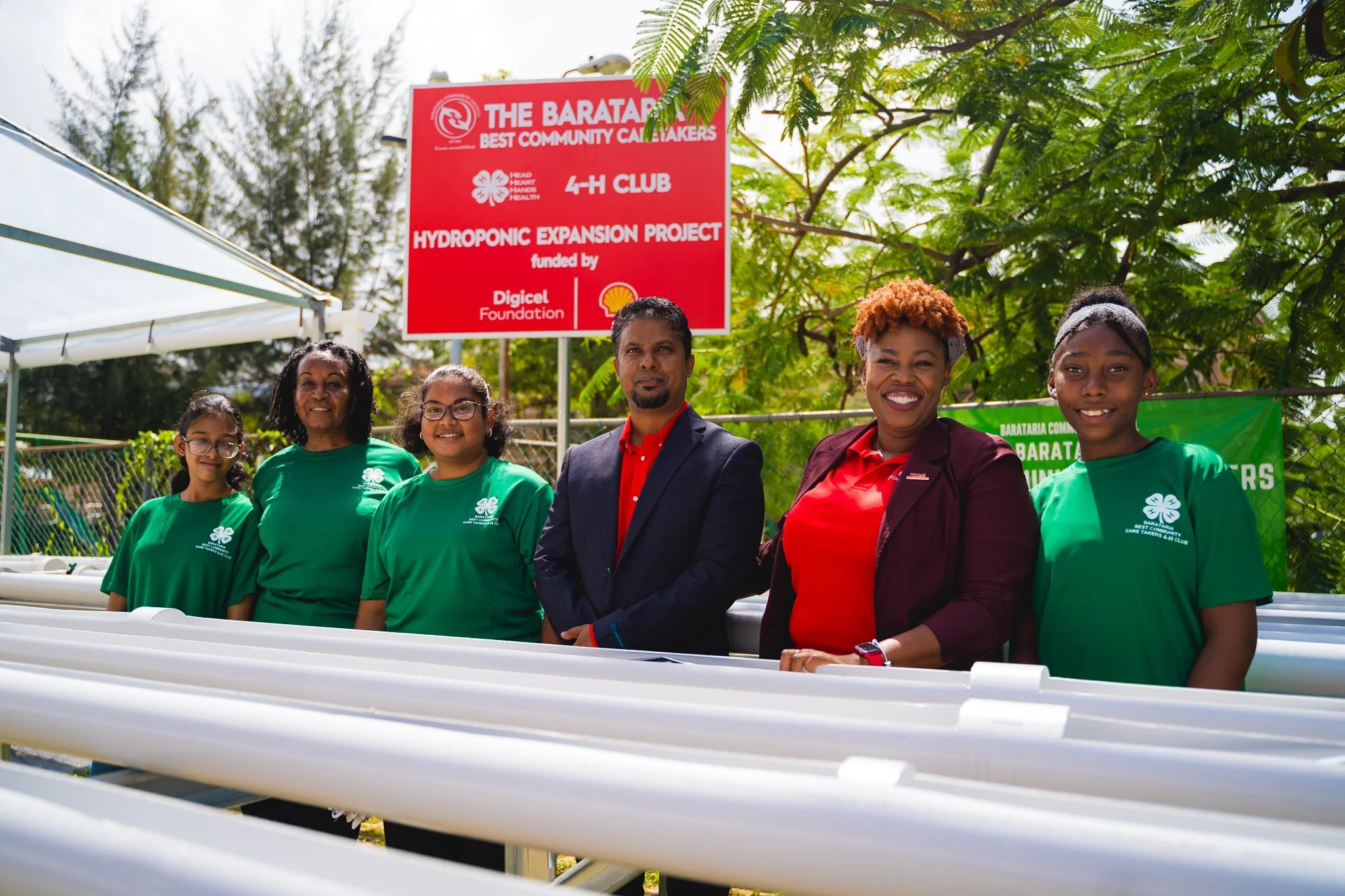 Cindyann Currency, Head of Operations at Digicel Foundation, and Terry Mohammed, Operations HSSE and Emergency Response Manager at Shell T&T, join Barataria's 4H Club on 31st January 2024 to launch their EPIC hydroponics expansion project.