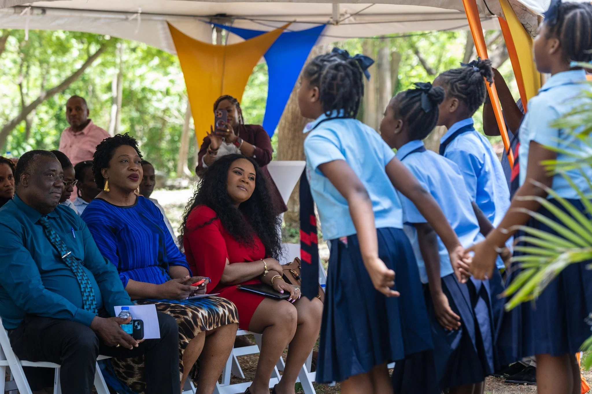 Minister of Sport and Community Development and MP for Tobago East the Honourable Shamfa Cudjoe and Assemblyman Nathisha Charles Pantin, Secretary for Food Security, Natural Resources the Environment and Sustainable Development, enjoy the performance by primary school children at the launch of the Canaan Bon Accord Crab Farm on April 12.