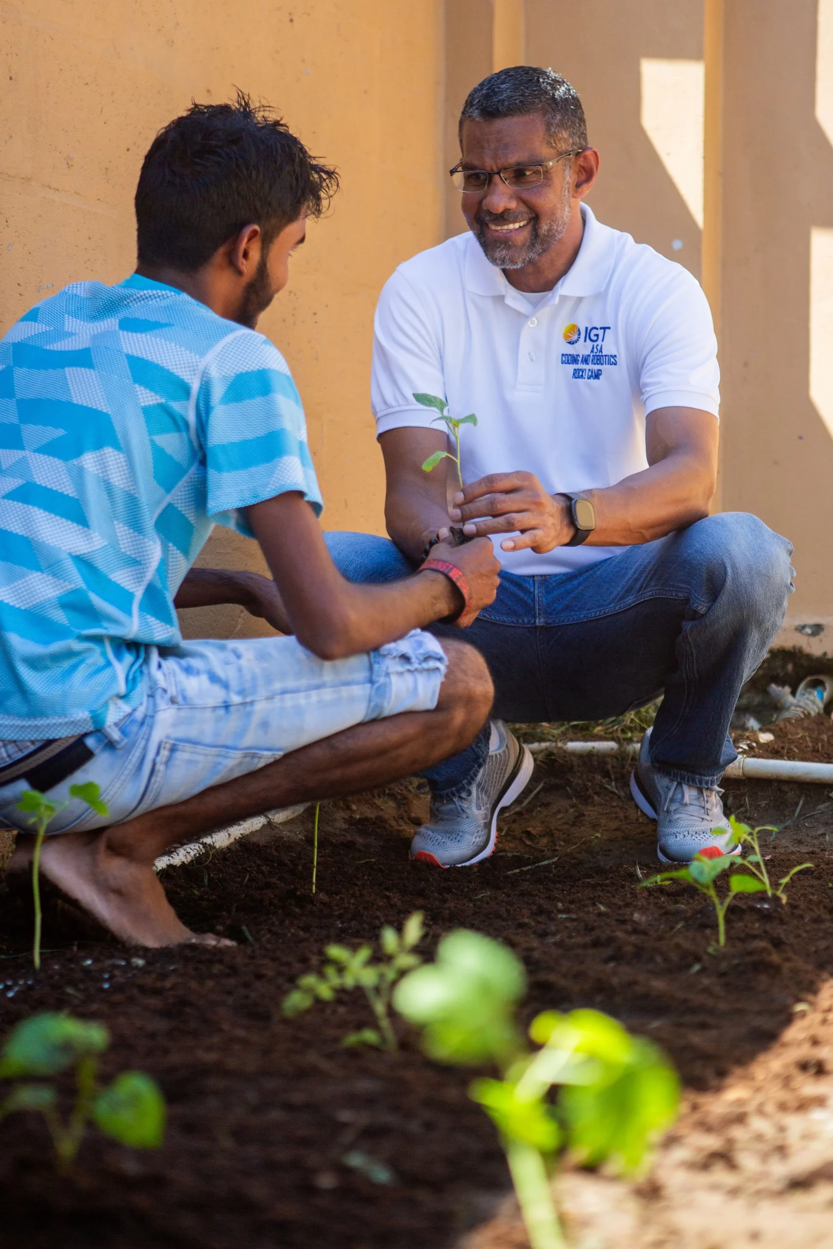 This young man from Rainbow Rescue put great care into helping build the home’s vegetable garden with encouragement from mentor Desmond Sydney, IGT Retail Manager (on the right).