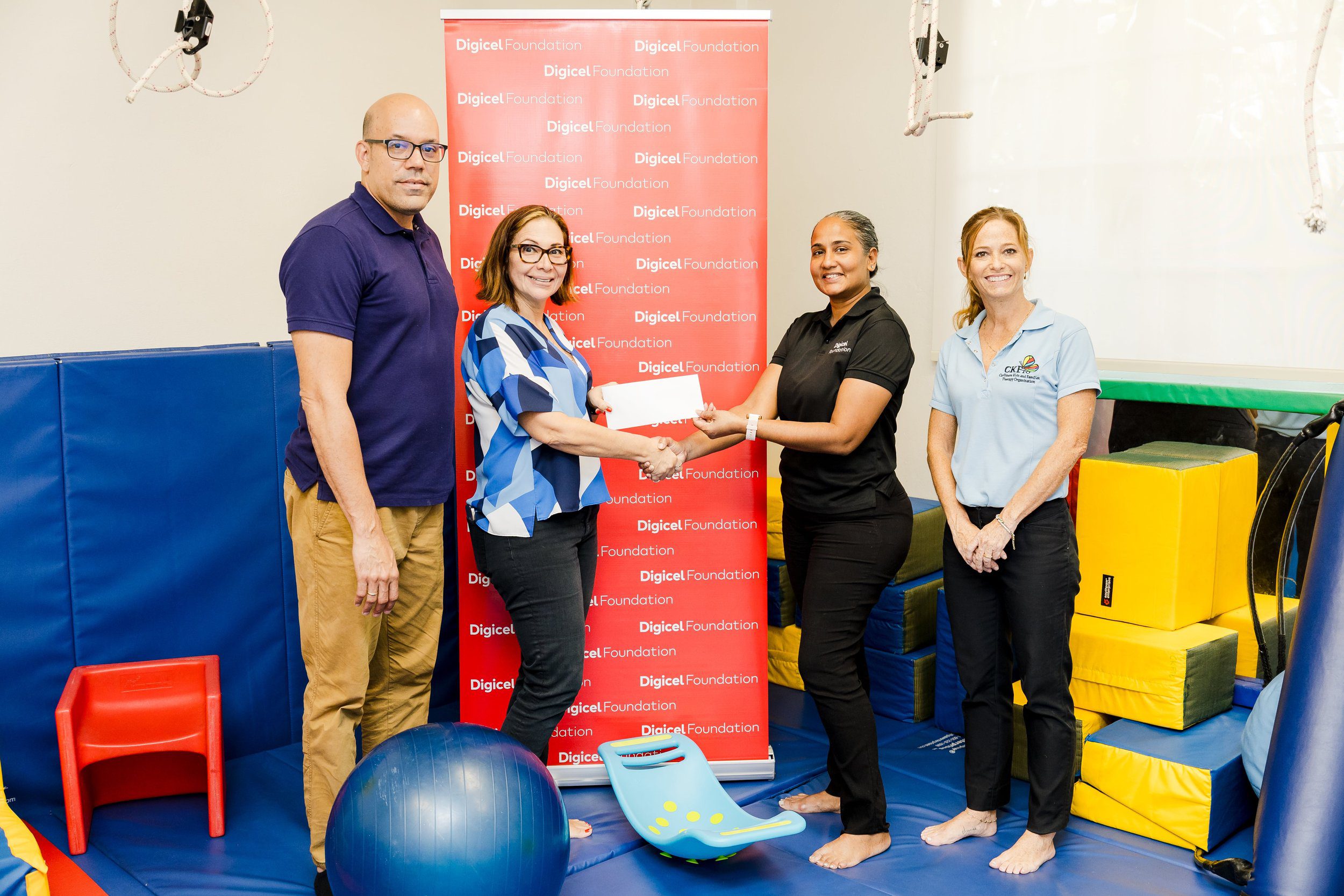 The Digicel Foundation’s Project Officer Diana Mathura-Hobson (centre right) hands over a donation to Sofia Figueroa-Leon, Vice Chair of CKFTO (centre left), in the company of Samuel Everdium, Cuevas Medek Exercises (CME) Specialist (left), and Krista Hamel-Smith, General Manager, CKFTO (right).