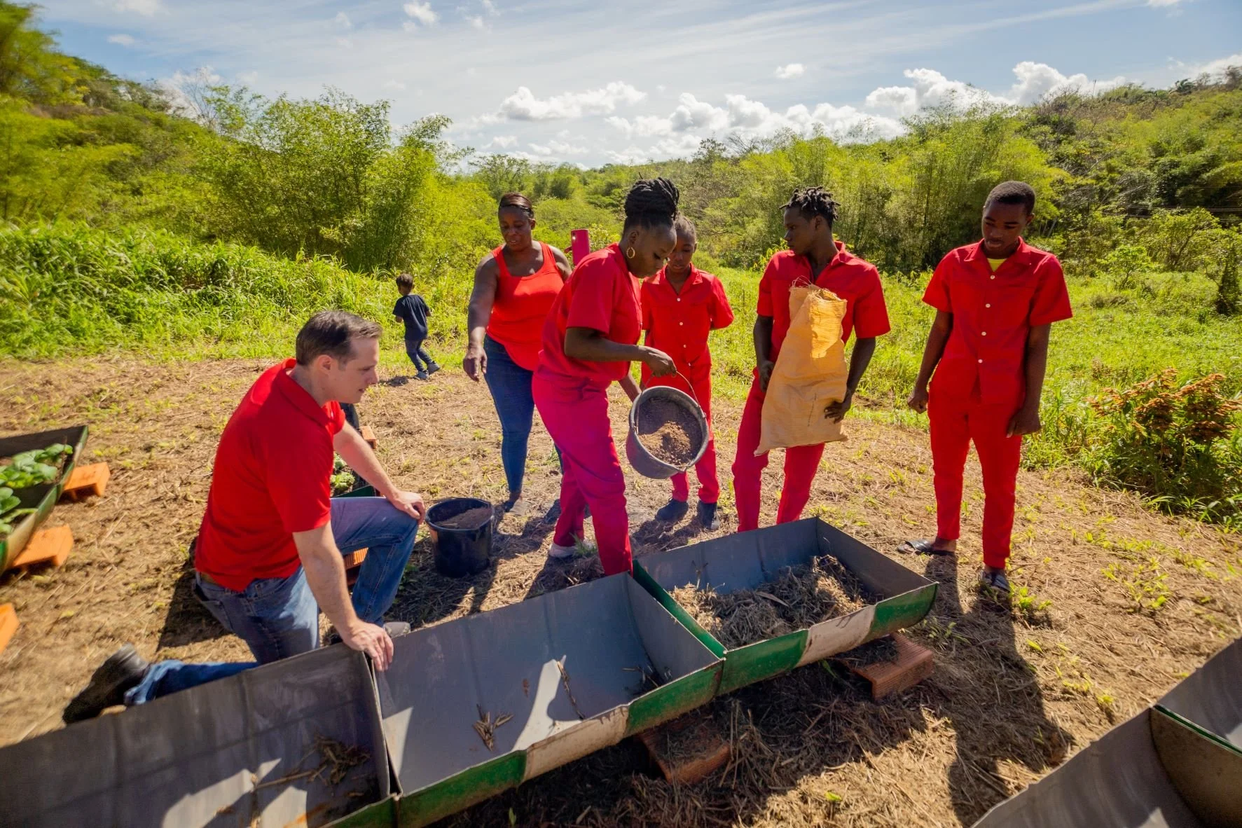 Digicel CEO Abraham Smith is given a demonstration on making organic compost by beneficiaries of ‘Planting Seeds with a Purpose’ project.