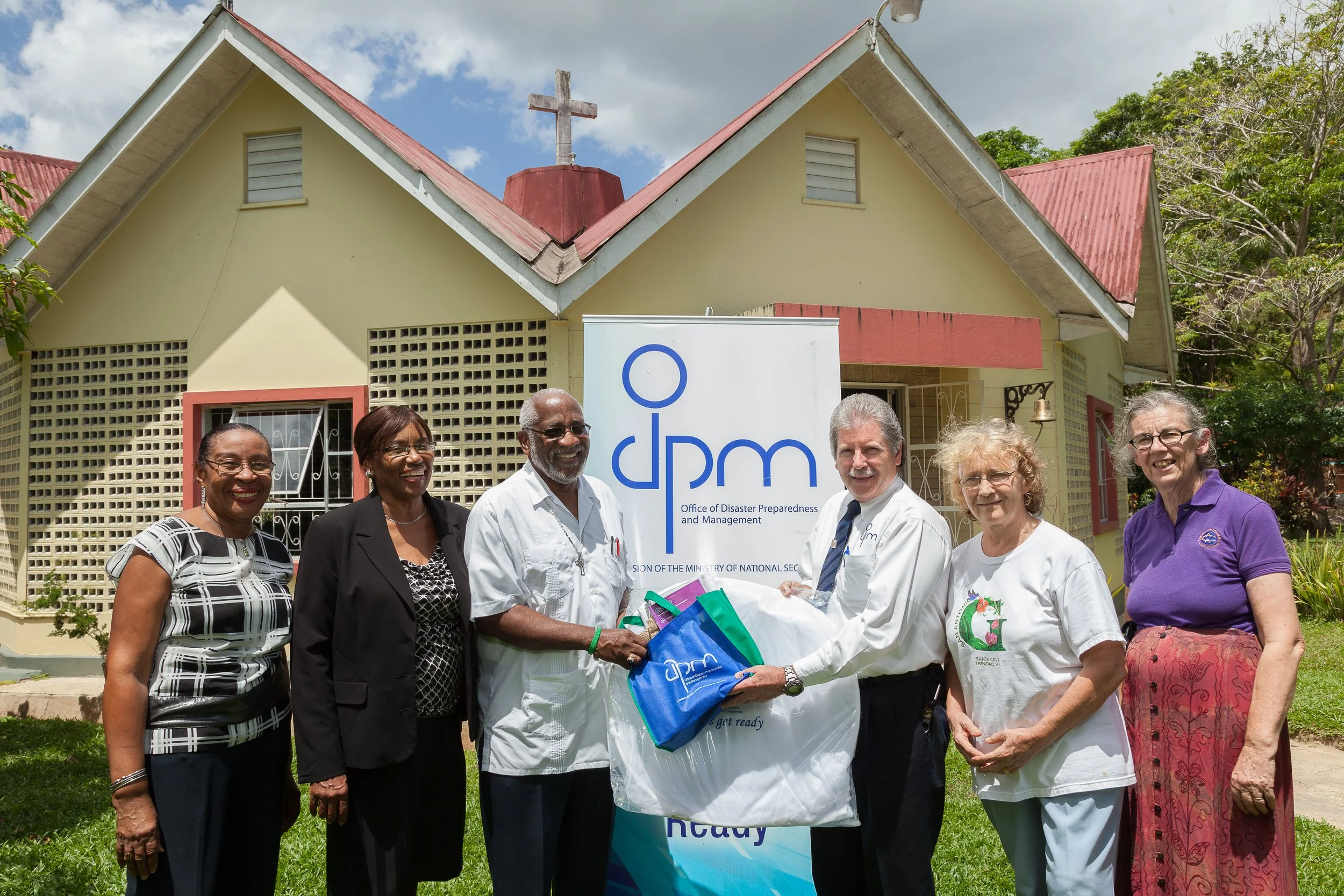 Handing Over: Eric Mackie, regional co-ordinator of the ODPM, centre right, presents disaster preparedness items to Canon Dr Steve West, centre left, rector of the All Saints parish, at the Chapel of Ease Anglican Church in Maraval, On Wednesday. Also attending the presentation were officials of the chapel, from left, Jacqueline Campbell, Vernetta Calvin-Smith, Kate Wong and Roberta White.
