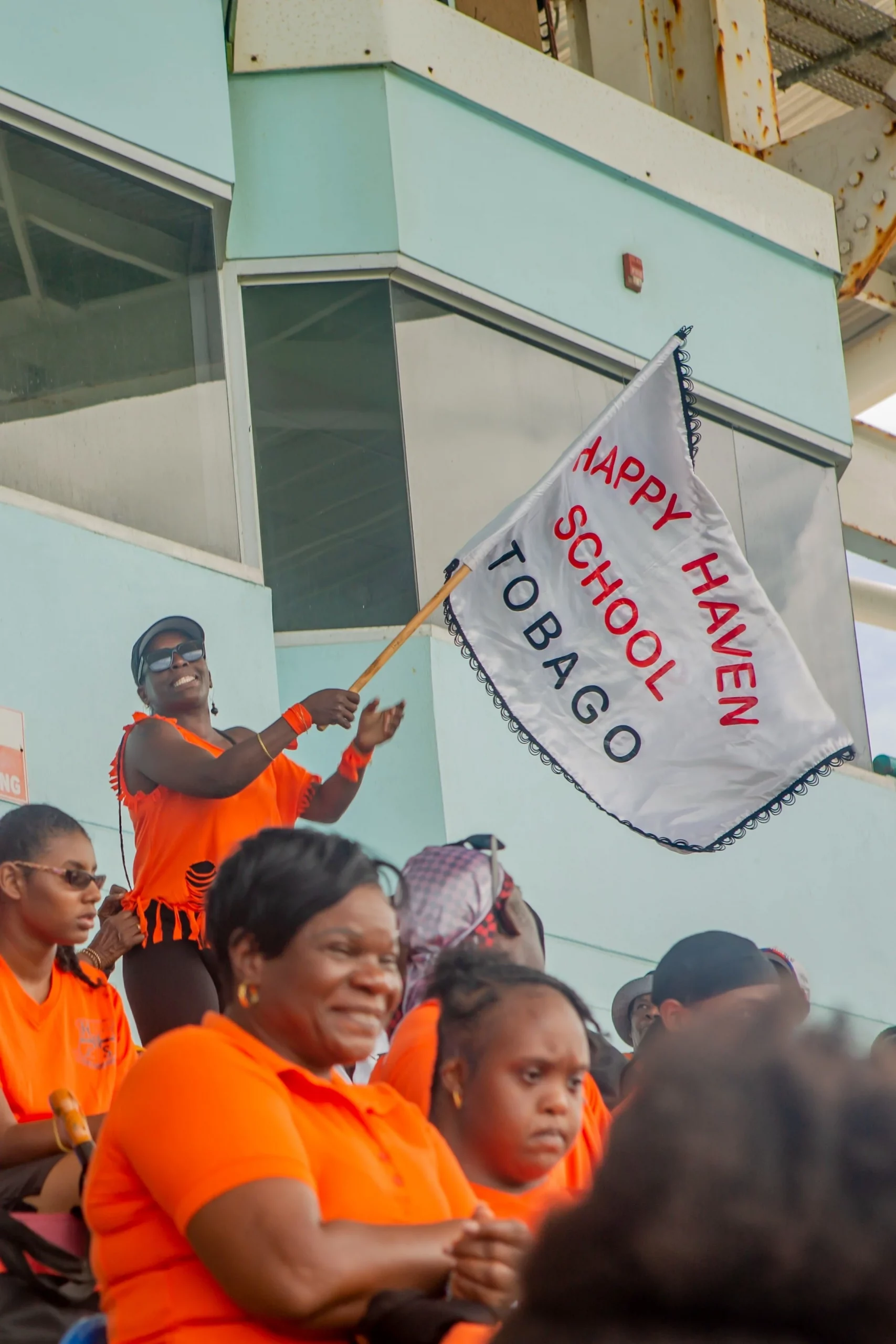 Showing her full support for Tobago’s Happy Haven School, this spectator proudly waves the school’s flag at the Dwight Yorke Stadium.