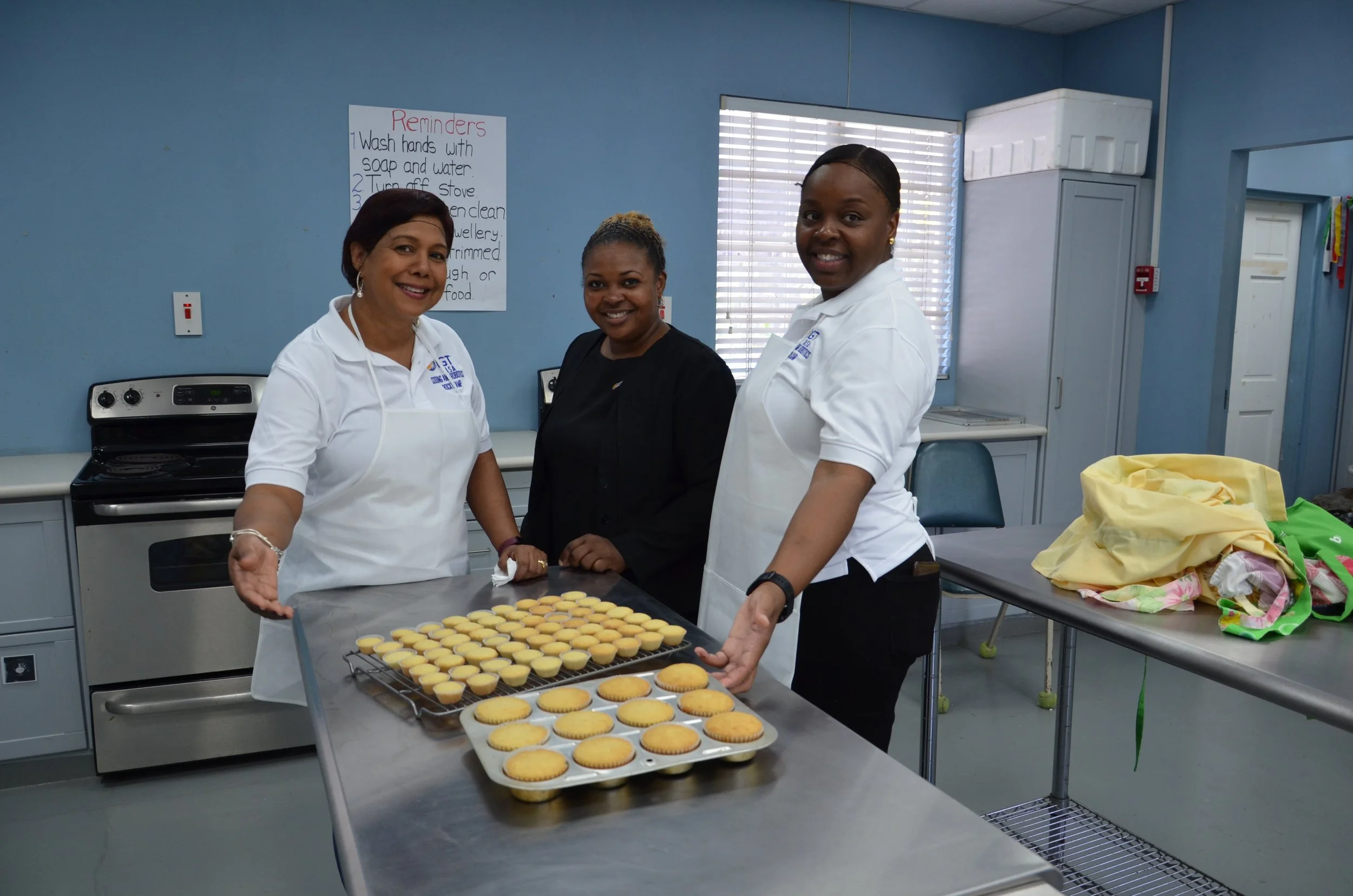 IGT team (from left to right) Shavindra Tewarie-Singh, Rowen Marshall and Akilah Howard proudly display the cupcakes made by students in a baking activity coordinated by IGT volunteers at the Immortelle Centre.
