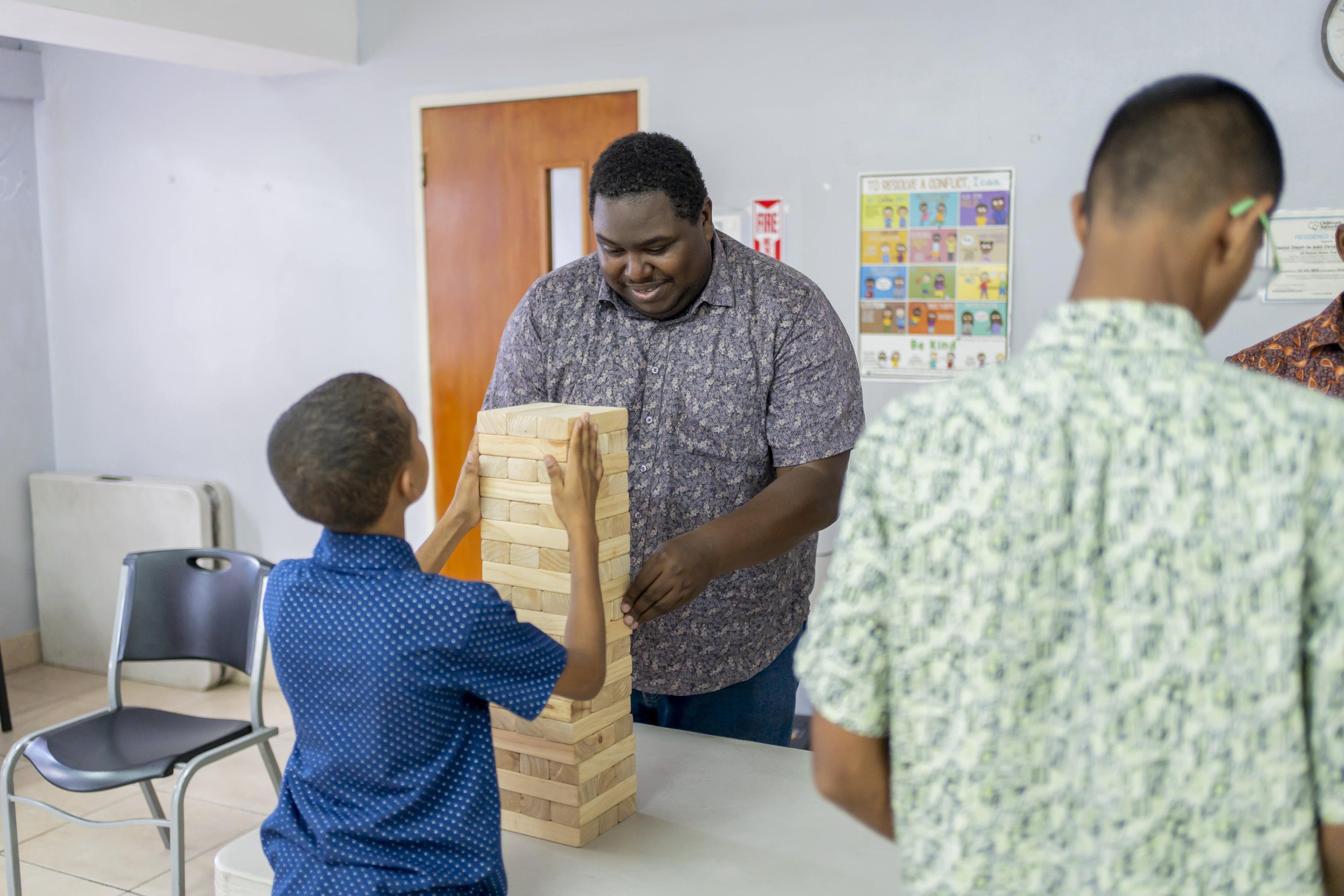 ‘Big Brother’ volunteer Sterling Toussaint, IGT Procall Representative, plays a game of Jenga at the Credo Home for Boys.