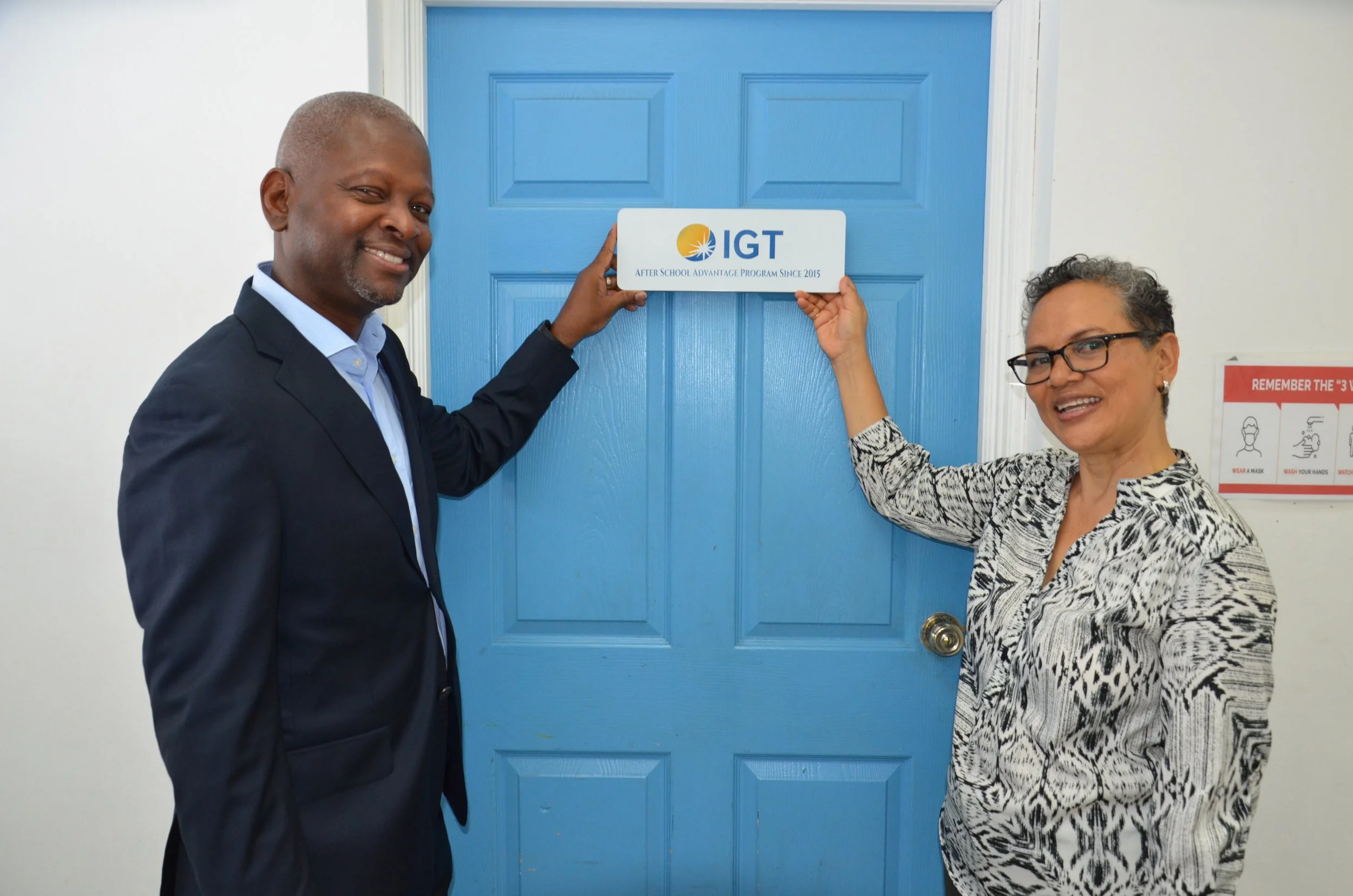 IGT General Manager Dexter W. Thomas and Immortelle Centre Principal Ms. Charlene Gittens place a commemorative plaque on the Centre’s computer room door, recognising their longstanding partnership dating back to 2015.