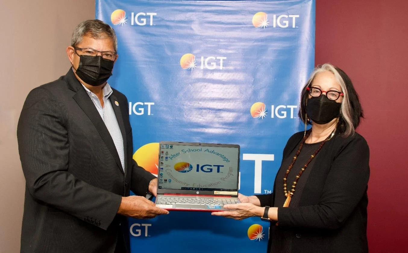 (L-R) IGT Country Manager Roger Bolai presents a laptop, part of IGT’s donation of technology, to Cotton Tree Foundation Chairperson Allyson Hamel-Smith during a brief handover ceremony.