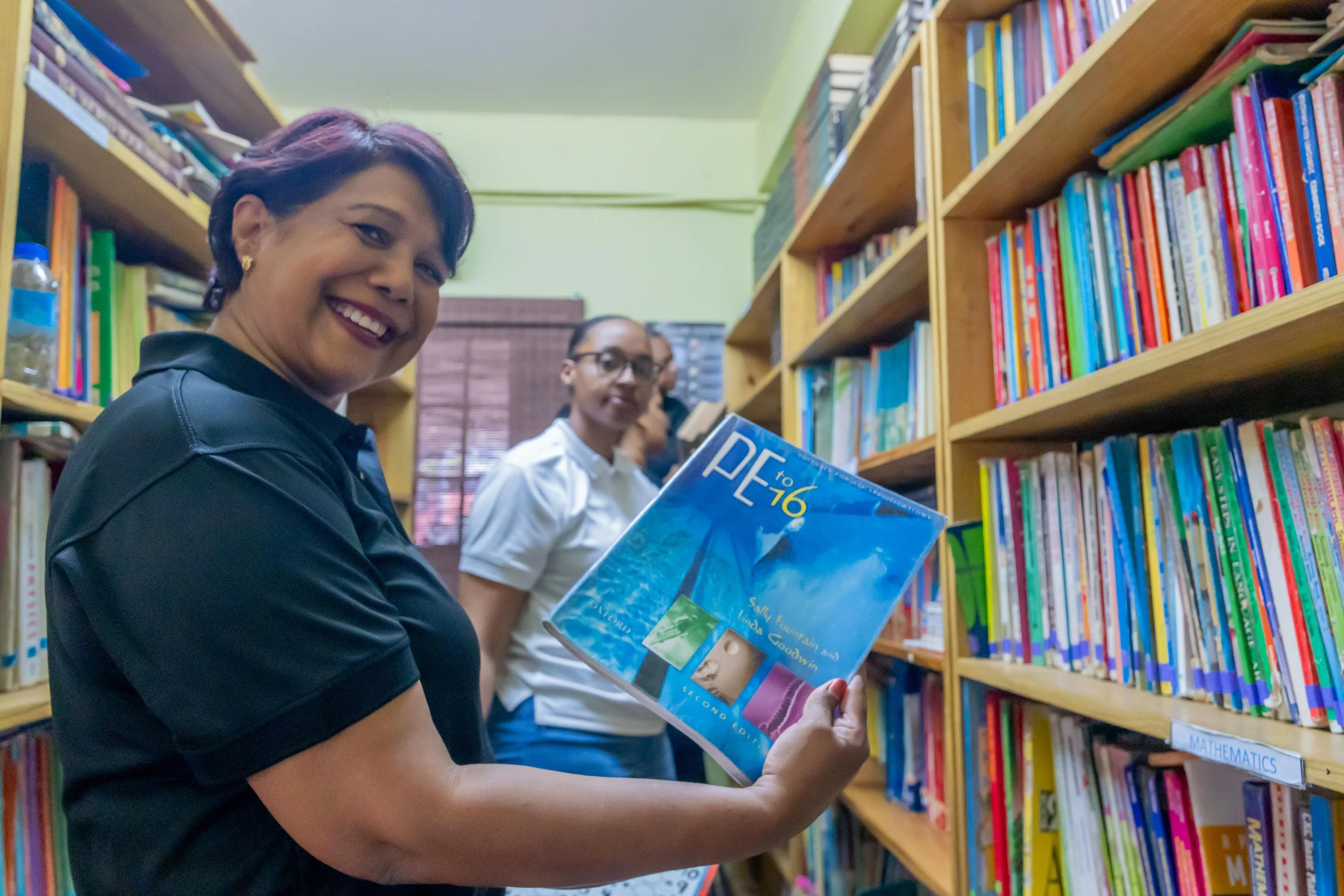  Marking the moment! Shavindra Tewarie-Singh, IGT People & Transformation Regional Senior Manager for the Caribbean, pauses from her volunteer work in the Amica House library to give a quick smile.  