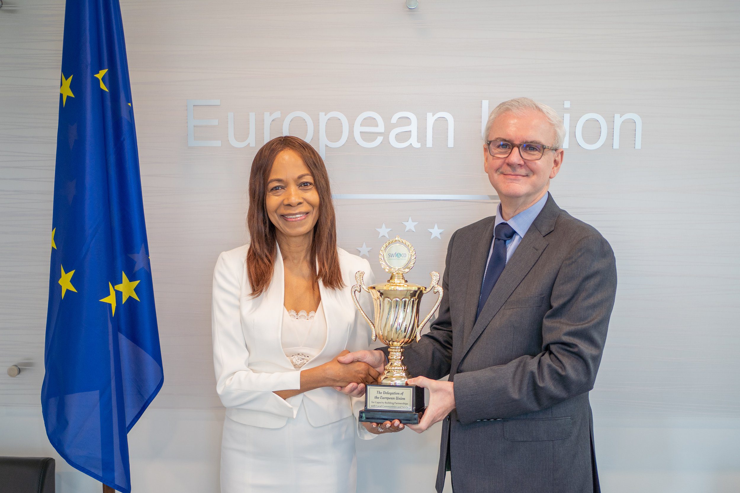 (L-R) CEO and Founder of SWF&CO Sandra Welch-Farrell presents an Award for Capacity Building Partnerships with Local Communities and NGOs to His Excellency Peter Cavendish, Ambassador Extraordinary and Plenipotentiary of Delegation of the European Union.