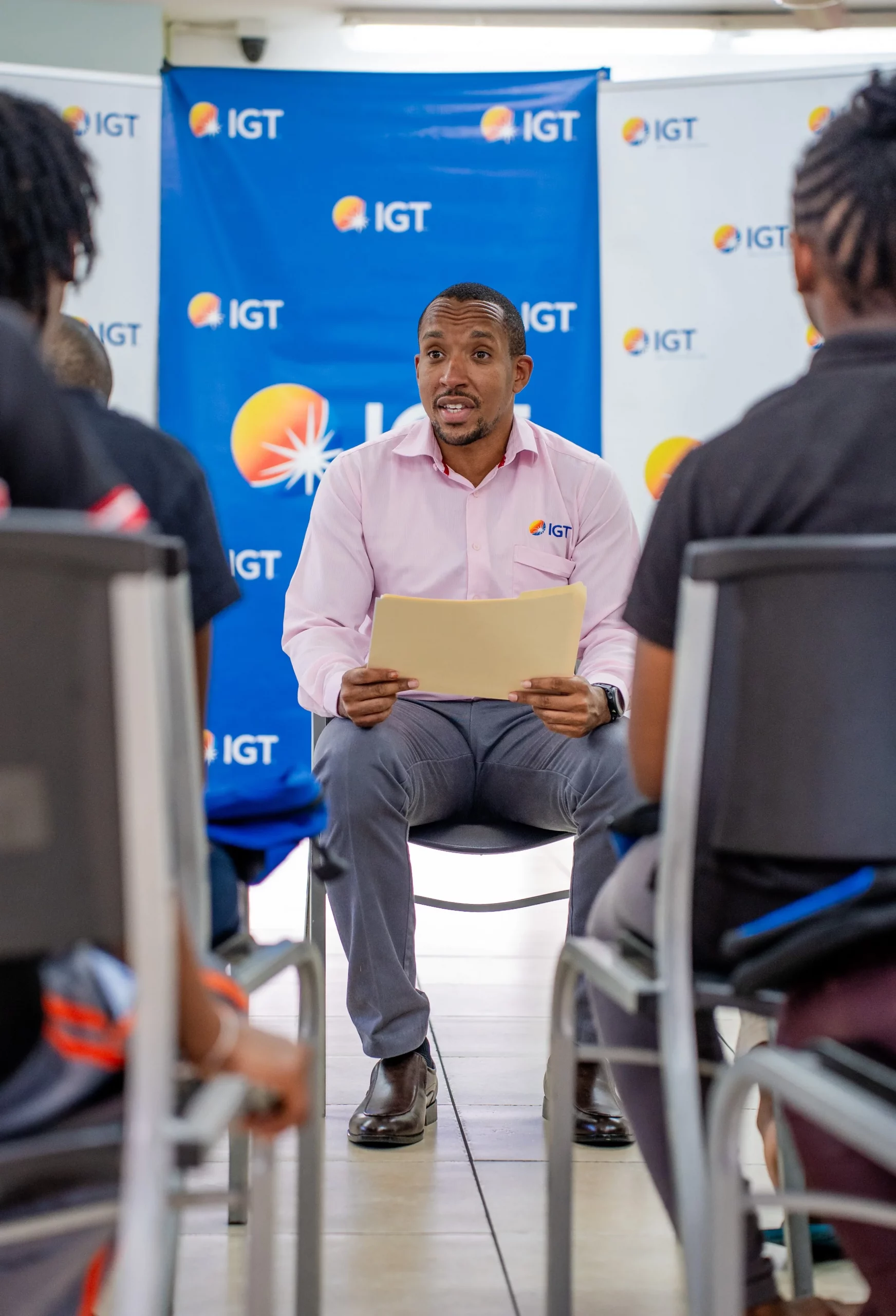 IGT employee Gabriel Nicholas reads a local folklore story about Papa Bois to youth beneficiaries of the Credo Foundation for Justice on August 28, 2023.
