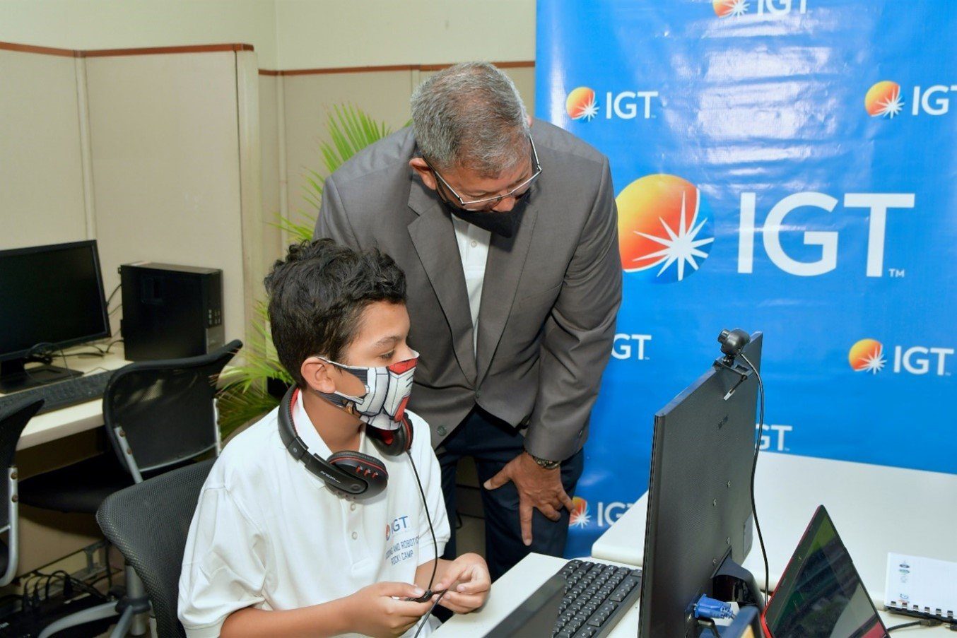 IGT Country Manager Mr. Roger Bolai oversees the work of one of the Cotton Tree Foundation’s students as he learns alongside his regional compatriots during the second staging of IGT’s Coding and Robotics Rock! Camp.