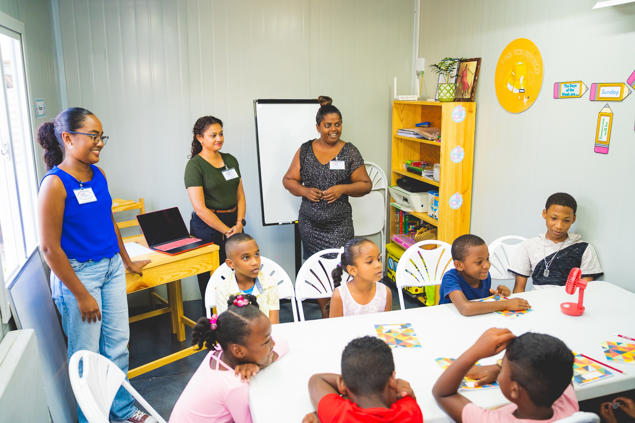 Volunteer teachers and Principal Shanna Dindial help students get settled for an activity session at the new homework centre launched with the support of The Digicel Foundation and Shell T&T.