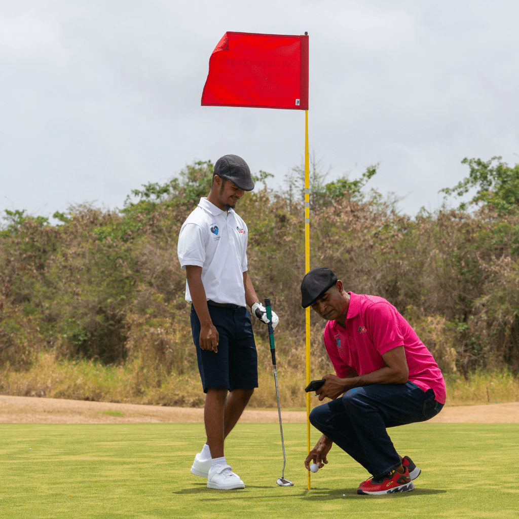 Zechariah Rostant (left), winner of the silver medal in the 3-Hole Golf competition and recipient of the Best Dressed Athlete award at the Tobago Games, shares a moment with his father, Steve Rostant, during the tournament held on May 25 at the Magdalena Grand Golf Course, Tobago.