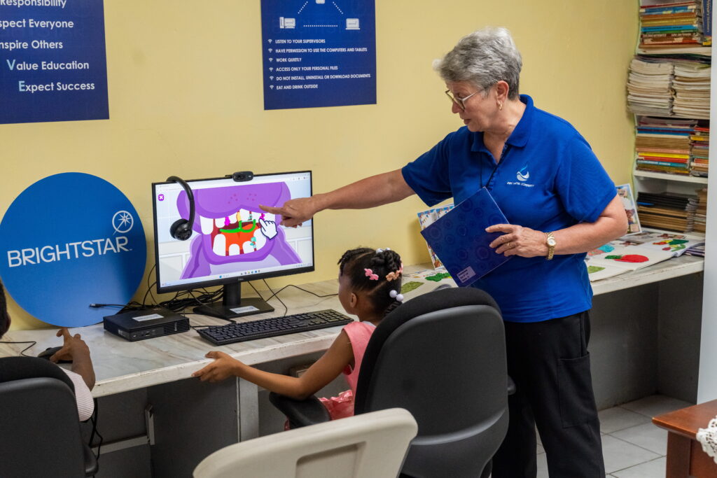 Jenni Jennings, Ministry Director at The Living Water Community, supervises this young resident of the Living Water Community Children’s Home Our Lady of The Wayside using the new desktop donated by Brightstar.