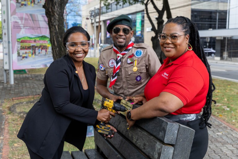 (L-R) Ryssa Brathwaite, Social and Performance Advisor, Shell Trinidad and Tobago; Denylle Yearwood, District Scout Commissioner, Northwest District; and Digicel Foundation Board Director La Toya Gopaul place signage on the recycled-plastic bench installed at the Brian Lara Promenade in Port of Spain.